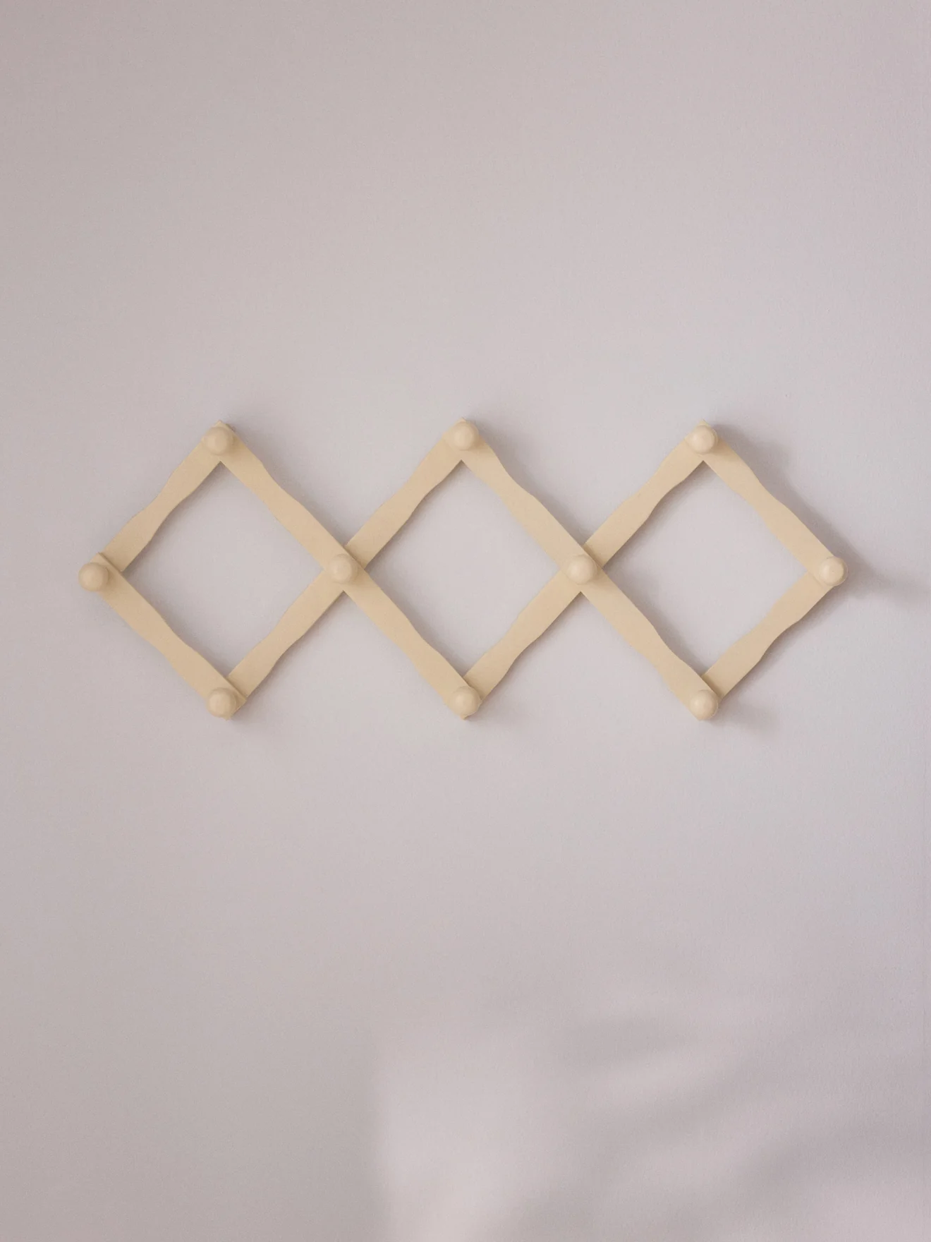 Ausziehbare Garderobe aus Holz im Akkordeon-Stil